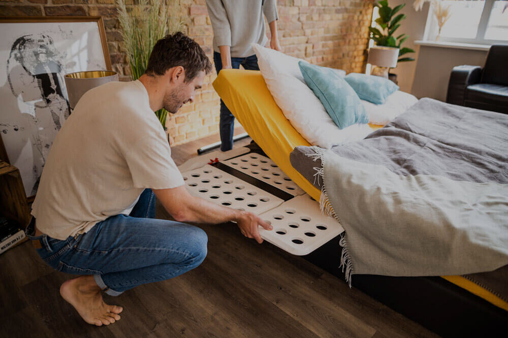 Man slides the CosyLift under the mattress