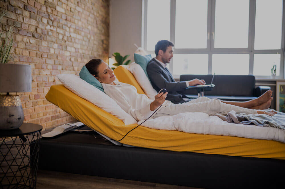 Woman and man are in the box spring bed with different angled CosyLifts