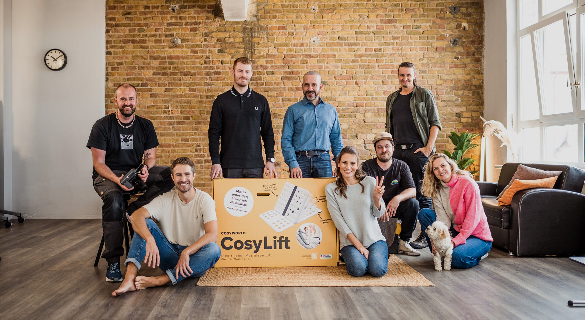 Gruppenbild vom Cosyworld Team, die um ein CosyLift Paket stehen
